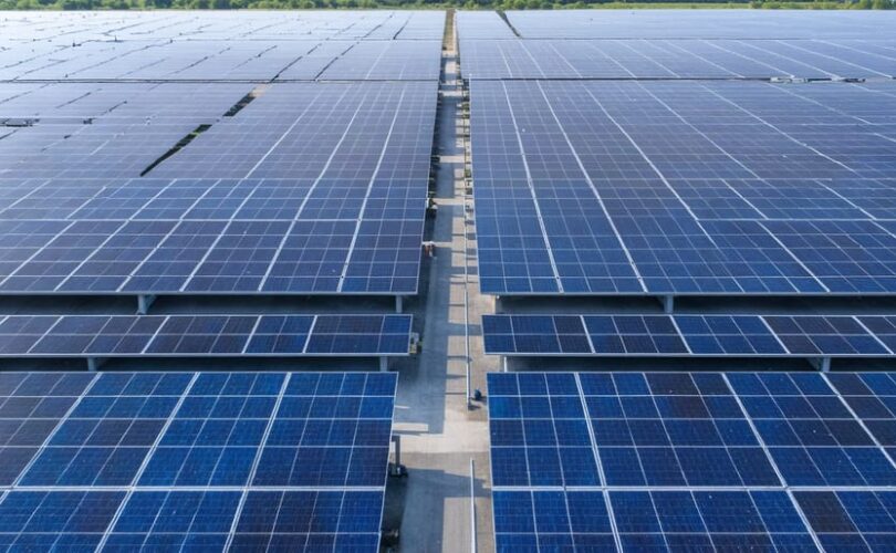 An illustration depicting government and private sector representatives collaborating at a large solar energy facility, symbolizing their partnership in driving solar innovation.