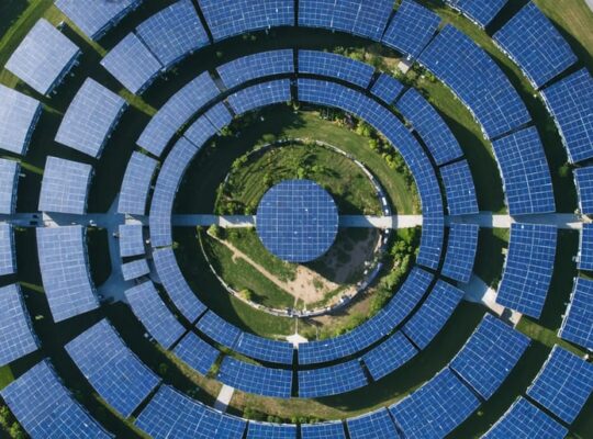Aerial view of a circular solar array installation with photovoltaic panels arranged in concentric circles, showcasing the innovative design and sustainable engineering principles.