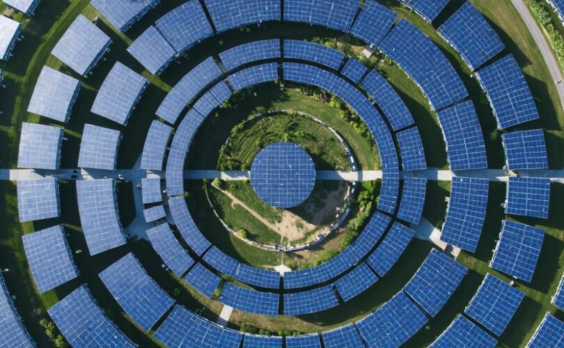 Aerial view of a circular solar array installation with photovoltaic panels arranged in concentric circles, showcasing the innovative design and sustainable engineering principles.