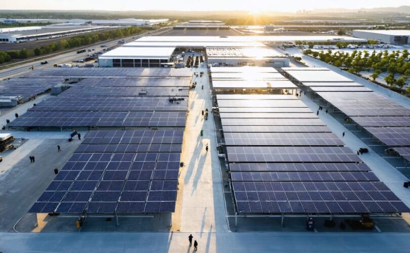 Aerial view of a cutting-edge solar manufacturing facility in the U.S., highlighting bustling production zones and solar panels gleaming under the sun.