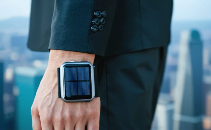 "Close-up of a futuristic wearable solar device on a wristband highlighting its flexible, energy-efficient design against an urban background."