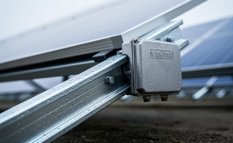 Close-up of a solar PV mounting rail and junction box with corrosion-resistant metal surfaces outdoors under soft daylight.